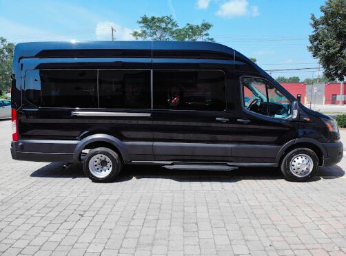 Spacious white 12-passenger rental minivan parked in Michigan, ready for group travel.