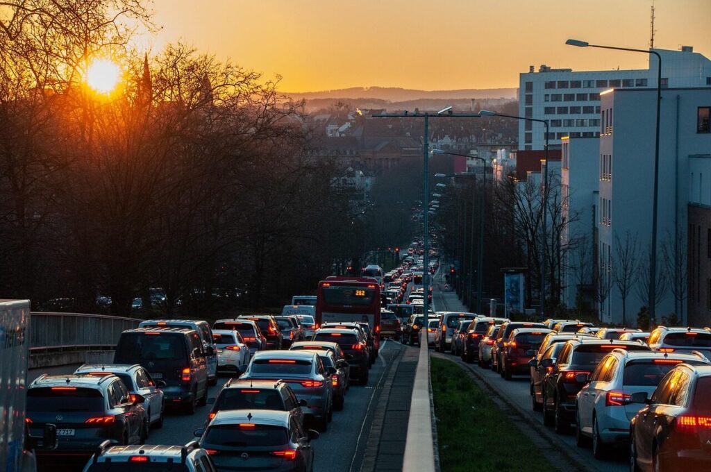 Heavy traffic jam on a city road during sunset with cars lined up in both directions.
