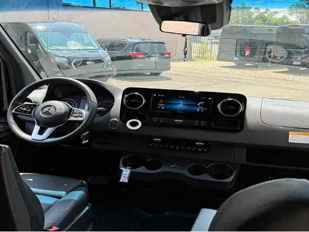 The image shows the interior of a van, showcasing the driver's seat, dashboard, and infotainment system.