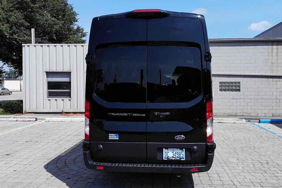 A large black colored van parked outside a building