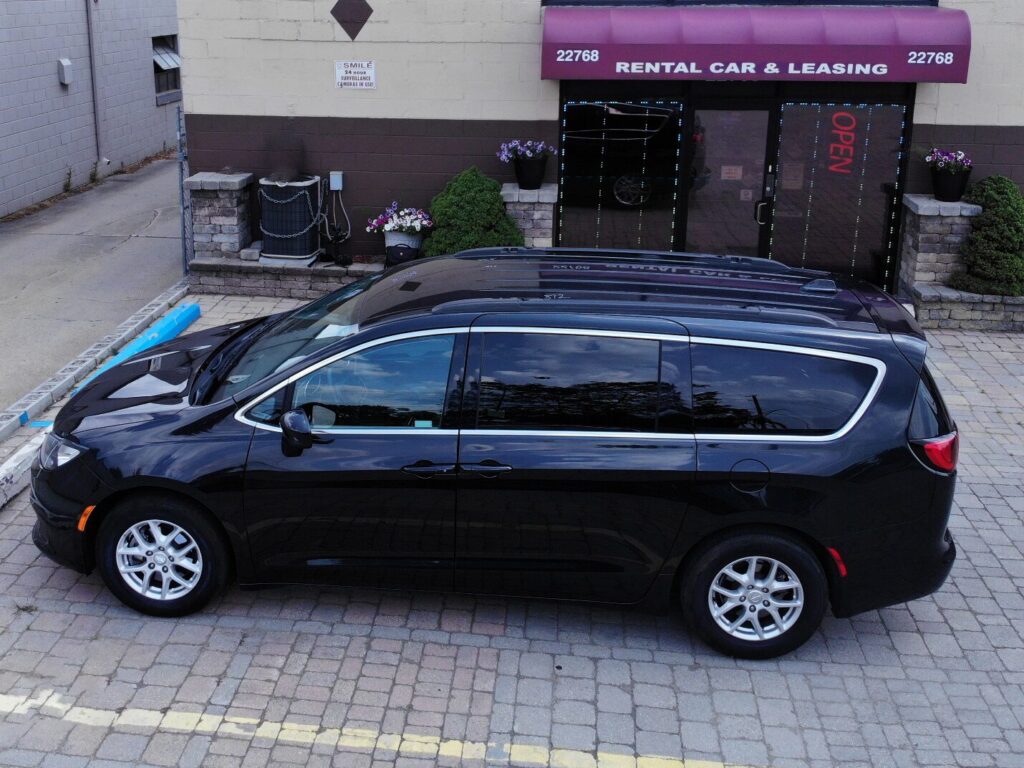 A sleek black passenger van parked outside, ready for a group