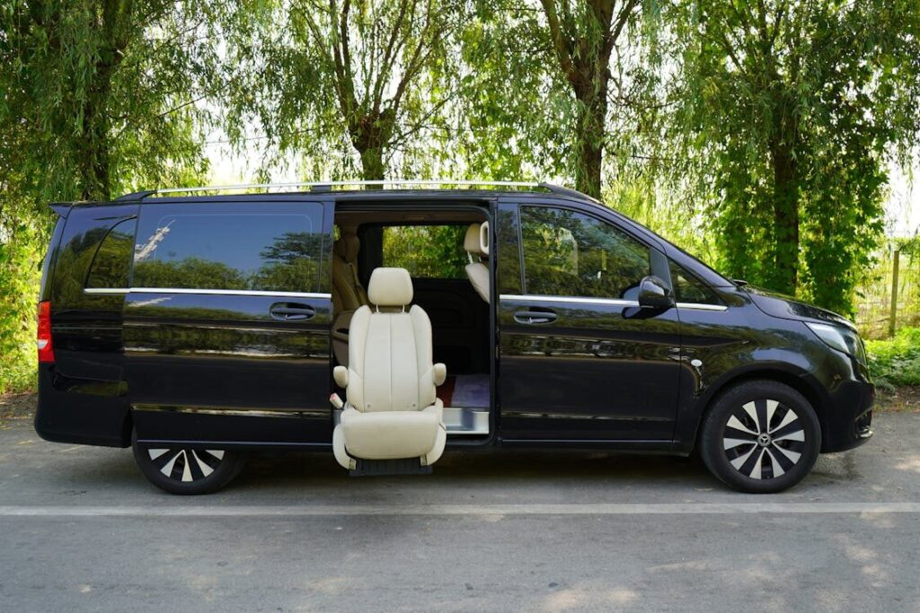 Black passenger van parked on a forest trail in Michigan during daylight