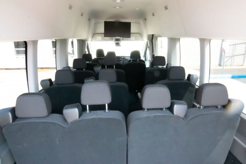 Interior view of a black passenger van with multiple rows of comfortable seating