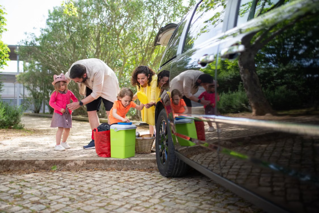 Black passenger van parked near a scenic Michigan fall destination with parents and children