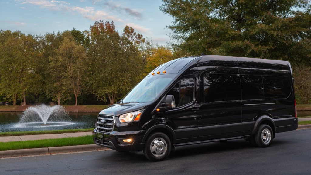 Black passenger van parked on a scenic Michigan road surrounded by trees