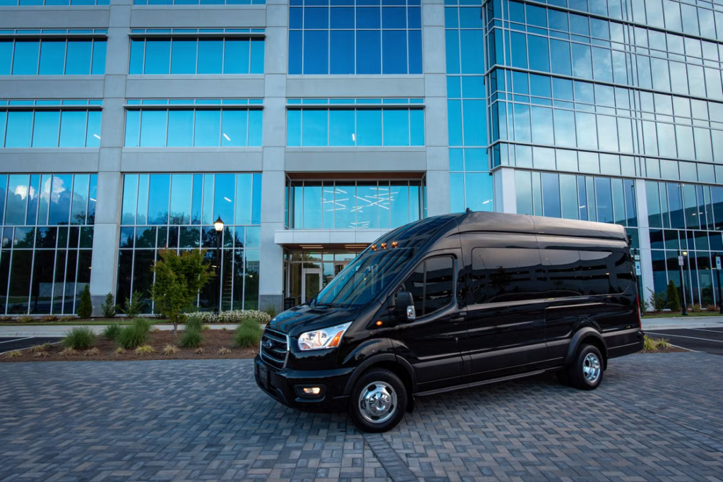 Black passenger van parked outside a university campus for group business travel