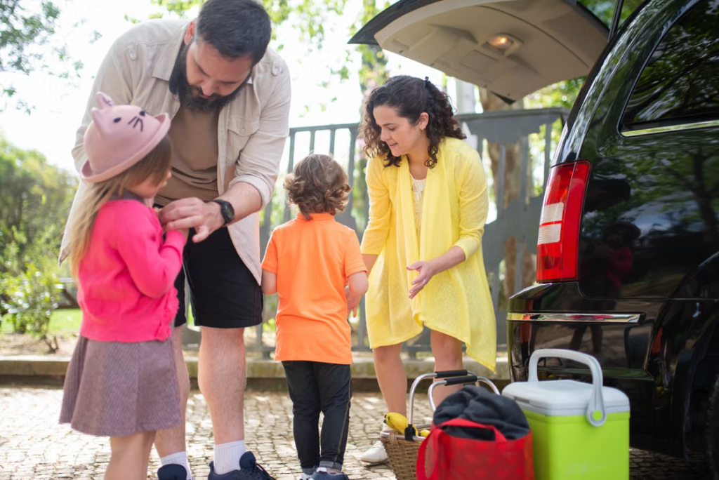Family members preparing to travel together beside a black passenger van in Michigan